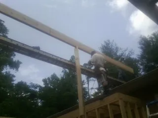 Carpenter setting a ridge beam over a new addition frame — Ice Dam Removal by Roofing Brothers in North Stonington