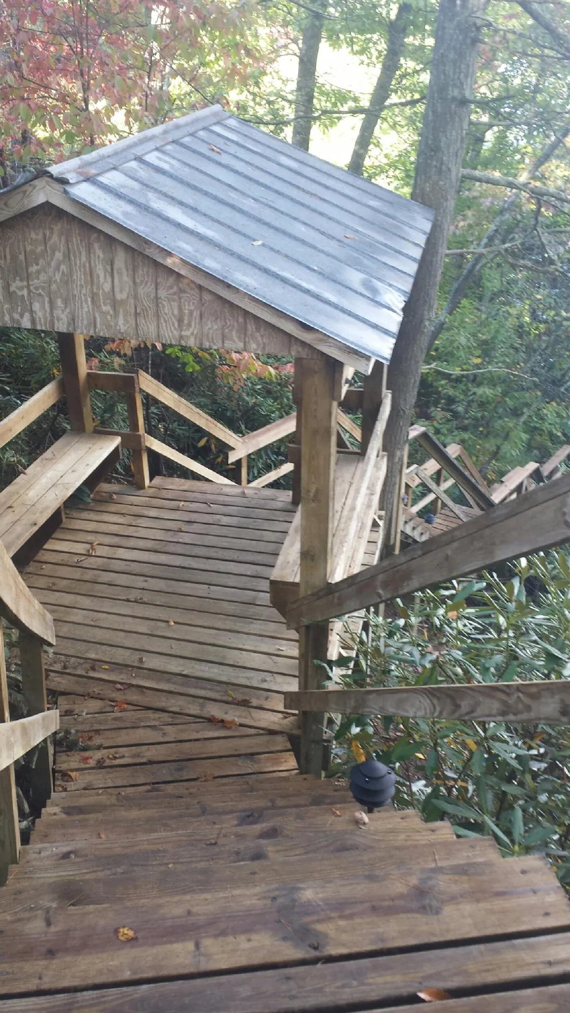 Metal roofed shelter over wooden steps on a wooded walkway — Skylight Repair & Installation work by our crew in North Stonington