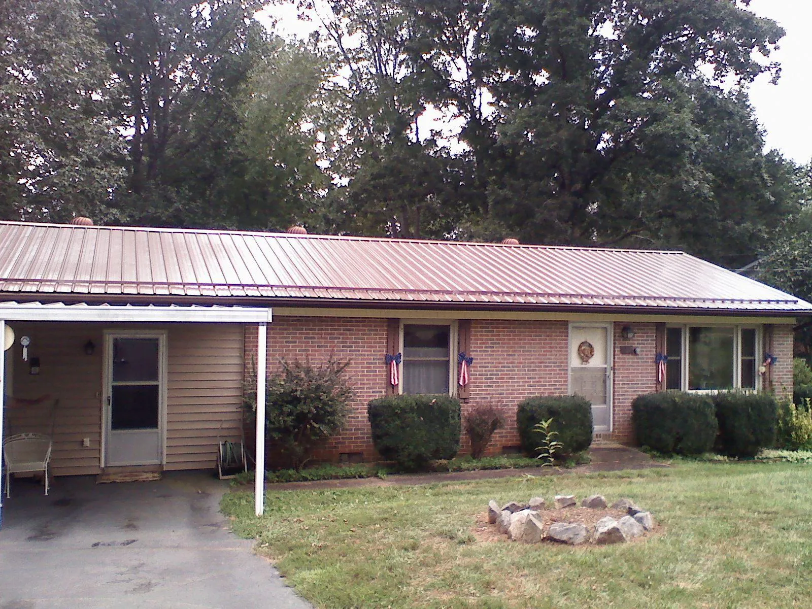 Bronze metal roof and carport on a brick ranch home — Roof Repair work by our crew in North Stonington